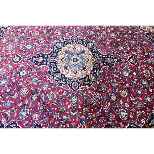 914 - A Persian Meshed carpet, the red/blue ground centred by a floral medallion, 373 cm x 300 cm