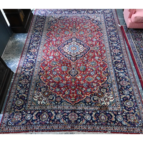 915 - A Persian Kashan carpet, the red ground centred by a blue floral diamond, 360 cm x 250 cm