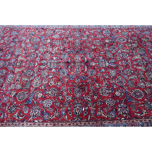 916 - A fine old Persian hand-made Kashan carpet, the red ground with repeating linked garden vine design,... 