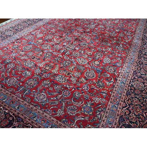 916 - A fine old Persian hand-made Kashan carpet, the red ground with repeating linked garden vine design,... 