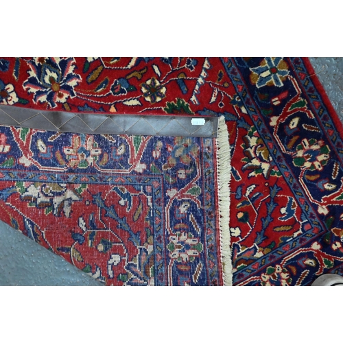 918 - A Persian Sarouk runner, the red ground with repeating design of interlinked floral vines, 307 cm x ... 