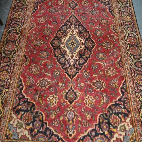 919 - A Persian Kashan rug, the soft red ground centred by a dark blue diamond medallion, 206 cm x 130 cm