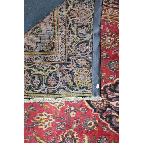 919 - A Persian Kashan rug, the soft red ground centred by a dark blue diamond medallion, 206 cm x 130 cm