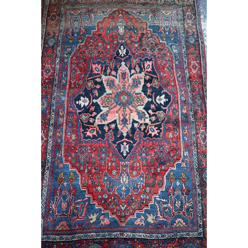 924 - A fine old Persian hand-made Bidjar carpet, the blue and red ground centred by a floral medallion, 2... 