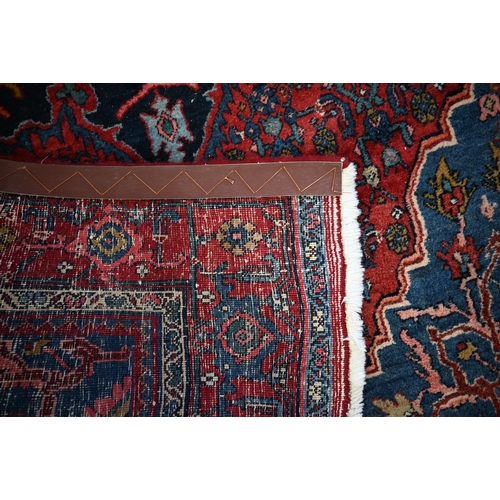 924 - A fine old Persian hand-made Bidjar carpet, the blue and red ground centred by a floral medallion, 2... 