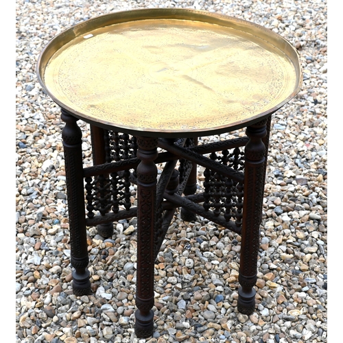 377 - An antique Ottoman circular brass top table, on a carved folding base, 58 cm dia. x 58 cm h