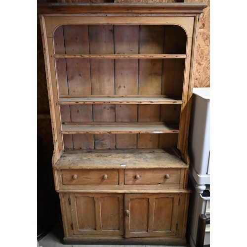 383 - An antique stripped pine single piece cottage dresser, with two drawers over two cupboards, 126 cm w... 