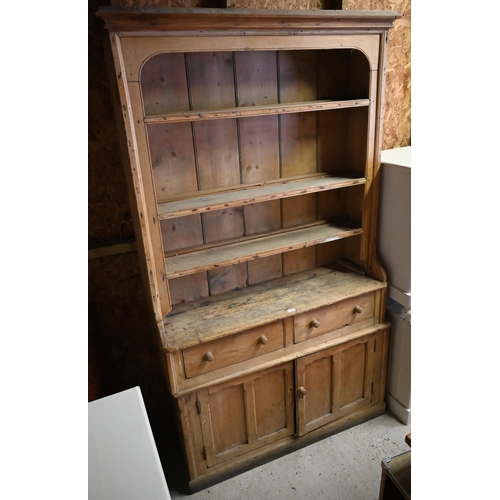 383 - An antique stripped pine single piece cottage dresser, with two drawers over two cupboards, 126 cm w... 