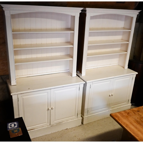 384 - A pair of painted pine library open bookcases, the four tier upper over a pair of cupboards, on plin... 