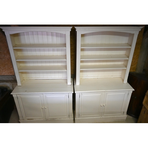 384 - A pair of painted pine library open bookcases, the four tier upper over a pair of cupboards, on plin... 