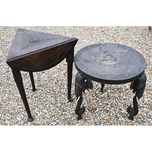 387 - An old carved Indian hardwood low circular tripod 'elephant' table, 59 cm dia. x 59 cm h, to/w a car... 