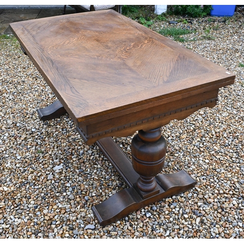 414 - An oak draw-leaf dining table raised on baluster turned ends united by a centre stretcher, 135 (247 ... 