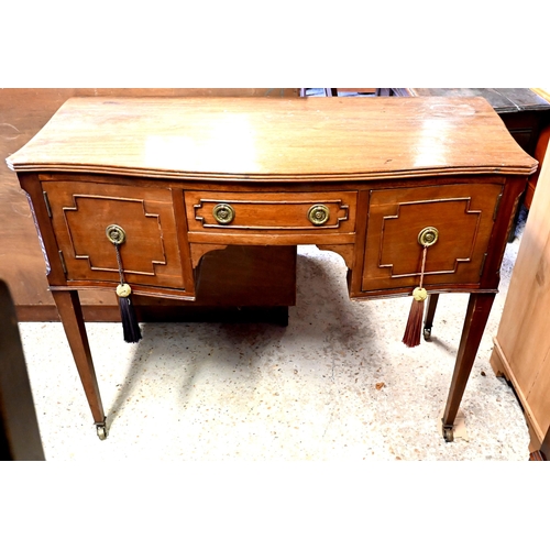 429 - A late Victorian mahogany serpentine kneehole side table/desk, on square tapered legs to ceramic cas... 