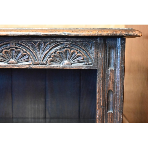 447 - An 18th century style oak part lunette carved open bookcase with pair of cupboard doors to base, on ... 