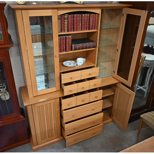 473 - A light oak wall unit with six drawers over two cupboards, with glazed doors revealing shelves, 150 ... 