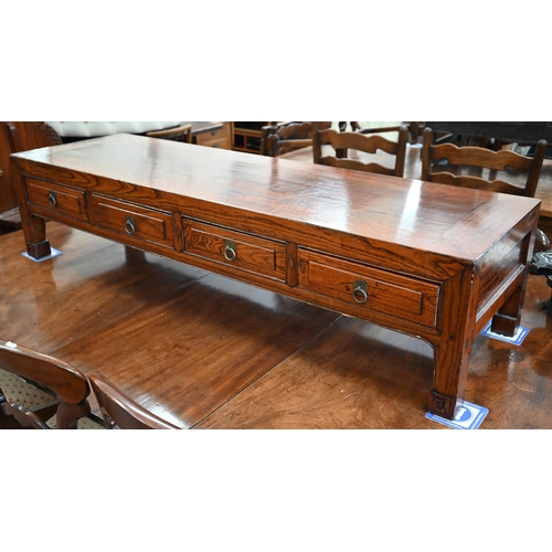 500 - A Chinese elm low table with four frieze drawers on sroll-carved supports, 141 x 43 x 33 cm high