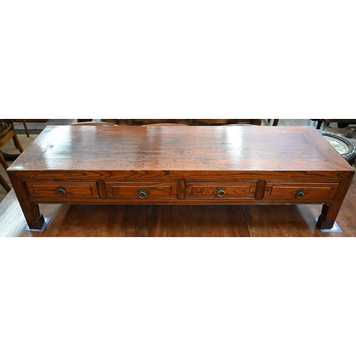 500 - A Chinese elm low table with four frieze drawers on sroll-carved supports, 141 x 43 x 33 cm high