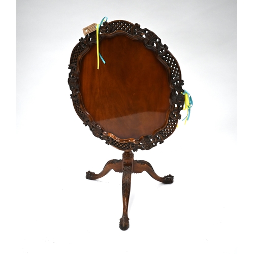 509 - A carved teak birdcage tilt-top tea table on tripod base with claw and ball feet, 77 cm diam