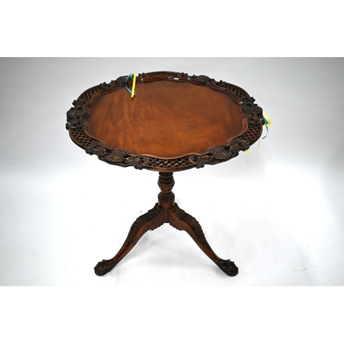 509 - A carved teak birdcage tilt-top tea table on tripod base with claw and ball feet, 77 cm diam