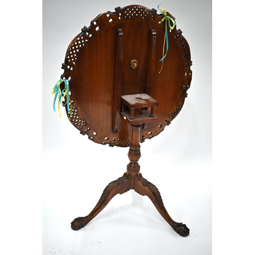 509 - A carved teak birdcage tilt-top tea table on tripod base with claw and ball feet, 77 cm diam