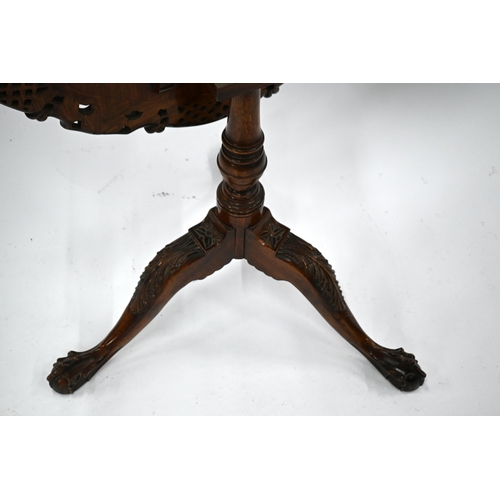 509 - A carved teak birdcage tilt-top tea table on tripod base with claw and ball feet, 77 cm diam