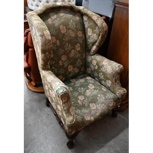 514 - An upholstered Victorian wing armchair raised on mahogany legs united by an 'H' stretcher, stamped '... 