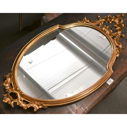 515 - Gilt-framed shield mirror with Rococo style crest and apron, 83 x 42 cm