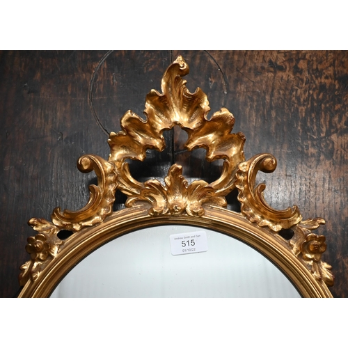 515 - Gilt-framed shield mirror with Rococo style crest and apron, 83 x 42 cm