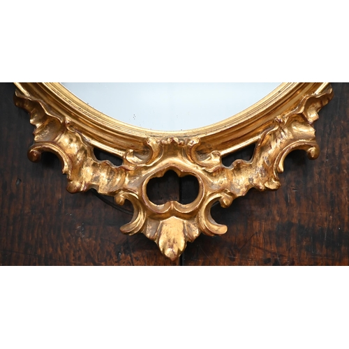 515 - Gilt-framed shield mirror with Rococo style crest and apron, 83 x 42 cm