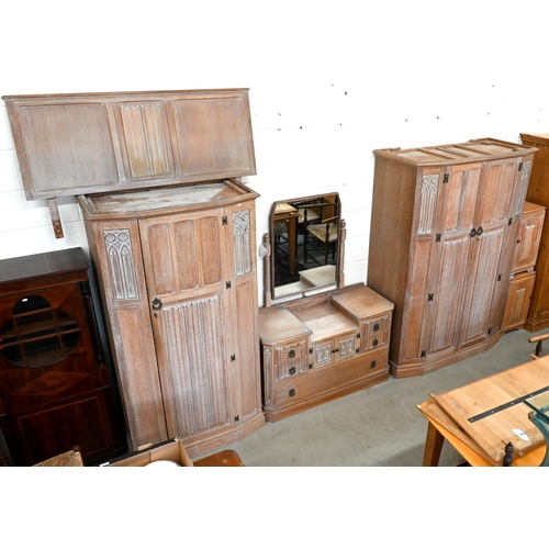 290 - A 'Crown Ay' limed oak bedroom suite with carved gothic arch and linenfold panels comprising double ... 