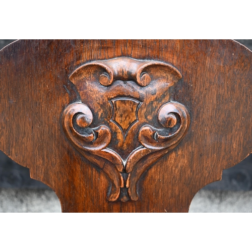 210 - A pair of Victorian armorial carved oak hall chairs with panelled seats and turned front legs (2)