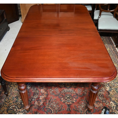 484 - A mahogany extending dining table in the Victorian style, raised on turned reeded legs to casters, c... 