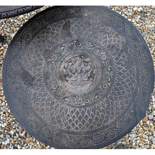 503 - An old carved Indian hardwood low circular tripod 'elephant' table, 59 cm dia. x 59 cm h, to/w a car... 