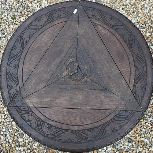 503 - An old carved Indian hardwood low circular tripod 'elephant' table, 59 cm dia. x 59 cm h, to/w a car... 