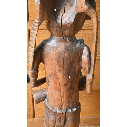 190 - A large Oceanic carved wood figure of a tribesman with extravagant winged headdress, necklace and lo... 