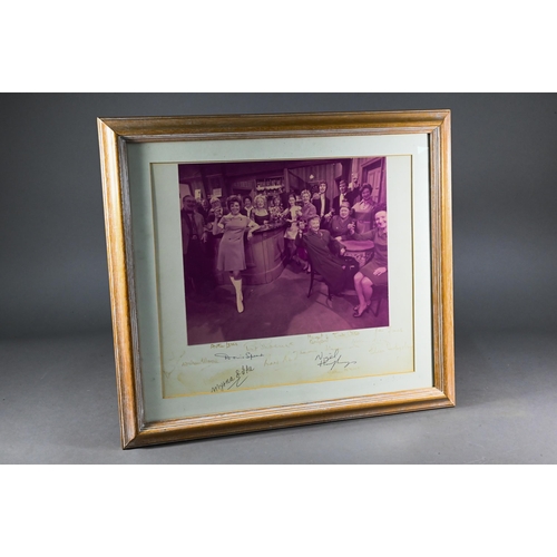 518 - A 1960s photograph of the cast of Coronation Street, taken in The Rovers Return, the mount signed by... 