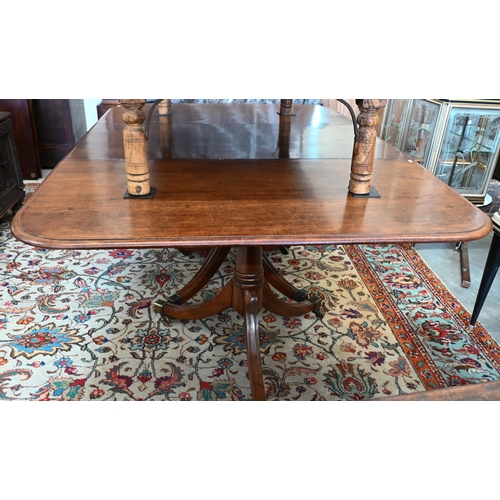 131 - A 19th century mahogany extending dining table, the rounded rectangular top in three sections on tri... 