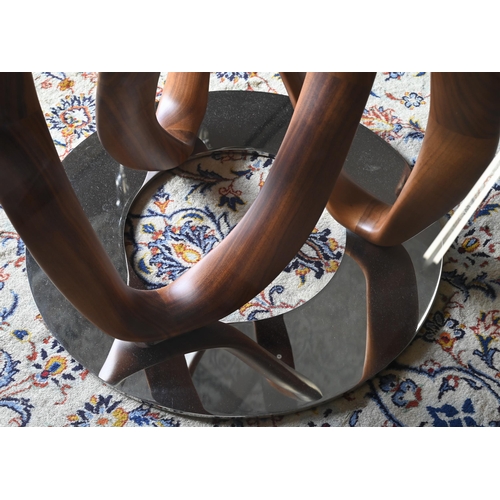 137 - An Italian Porada Infinity dining table with circular glass top on an American walnut Mobius loop st... 