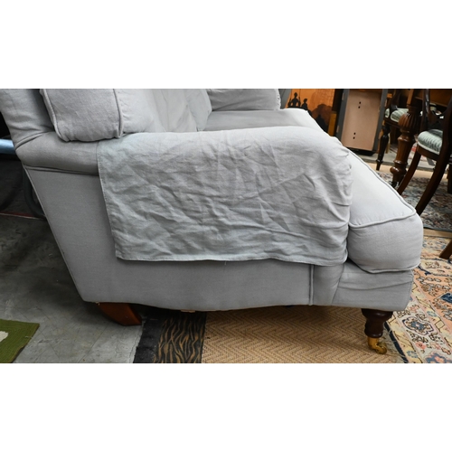 148 - A Howard style three seater sofa, turned mahogany front legs with brass castors, pale blue upholster... 