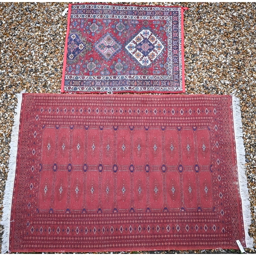 151 - A red ground Tekke Bokhara rug with typical repeating gul design, 190 x 125 cm, to/w a Persian Heriz... 