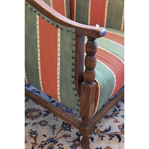 161 - An early 20th century oak framed armchair with green and red striped fabric uphostery