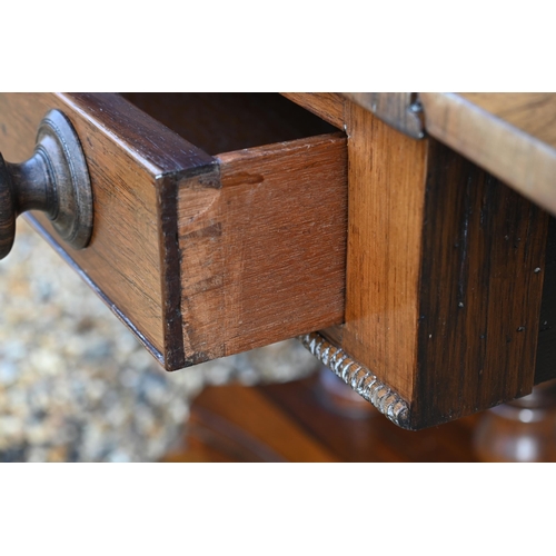 168 - A Regency rosewood sofa table (damaged leaf) with two drawers and concaved platform base with splaye... 