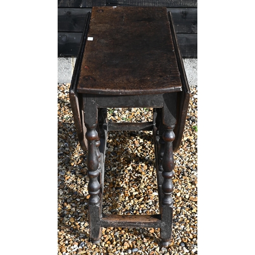 175 - An 18th century oak drop leaf dining table on gate-leg action turned supports