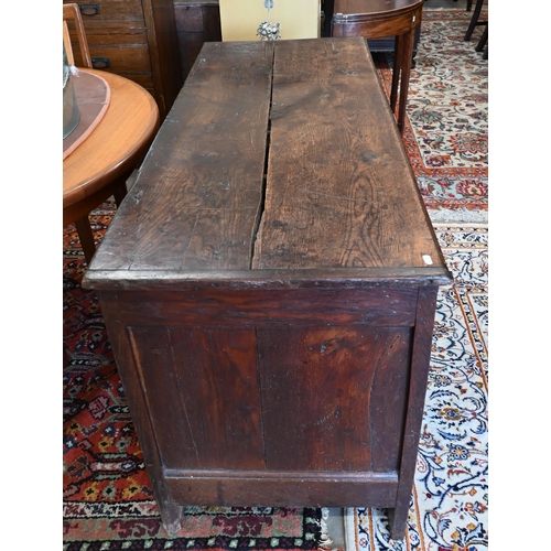 213 - A large antique panelled oak coffer, hinged top enclosing the deep storage area, 138 cm wide x 56 cm... 