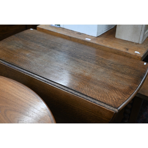 216 - An early 20th century oak drop-leaf dining table on gateleg action with barley twist supports