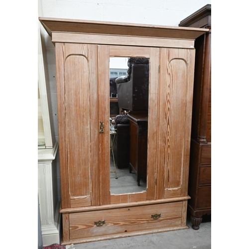 232 - A pitch pine wardrobe with panelled front centred by mirrored door over single drawer base, 140 cm w... 