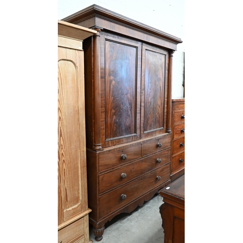 233 - A 19th century figured mahogany linen press, the panelled doors with column mouldings enclosing four... 