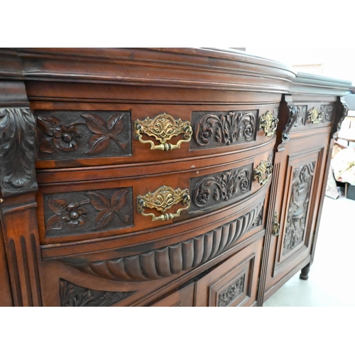 239 - A large late Victorian mahogany sideboard with floral and foliate carved door panels and drawer fron... 