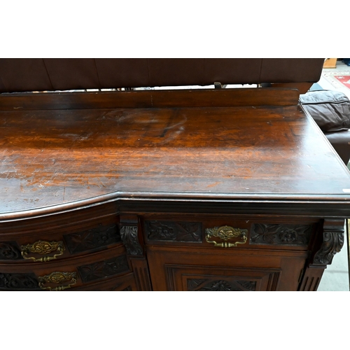 239 - A large late Victorian mahogany sideboard with floral and foliate carved door panels and drawer fron... 