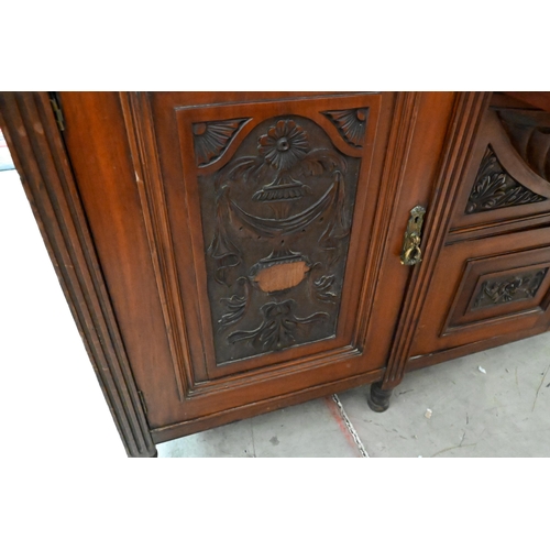 239 - A large late Victorian mahogany sideboard with floral and foliate carved door panels and drawer fron... 